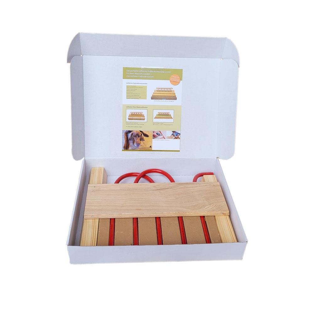Geöffnete Lethermo Muster-Box mit Dielenstück, Lehmelementen, roten Rohrstücken und Holzleisten