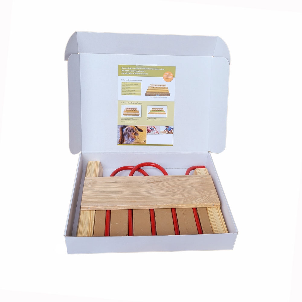 Geöffnete Lethermo Muster-Box mit Dielenstück, Lehmelementen, roten Rohrstücken und Holzleisten